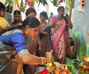 Women performing a traditional ritual with lamp and offerings while others stand around during a colorful school cultural celebration.