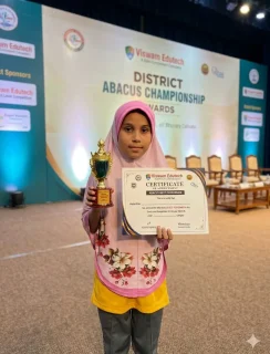 School student holding a certificate and trophy in the classroom with posters and drawings, celebrating academic excellence and competition success.
